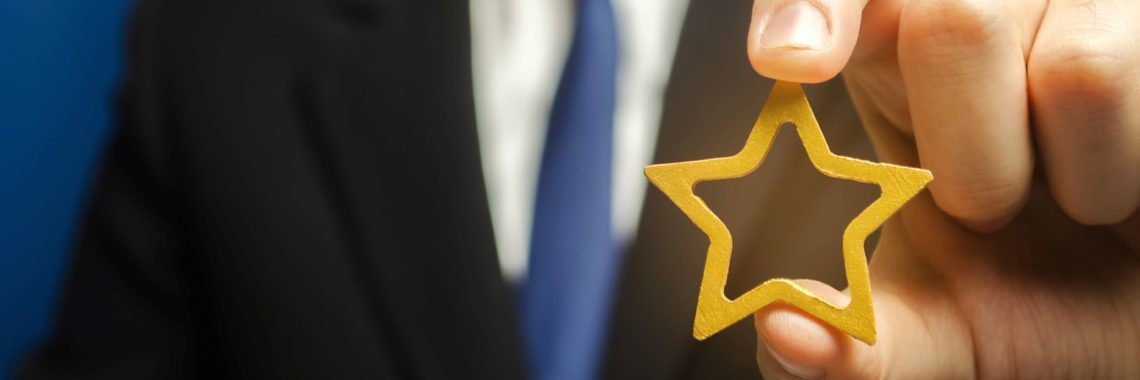 man holding a golden star in his hand, our history and milestones